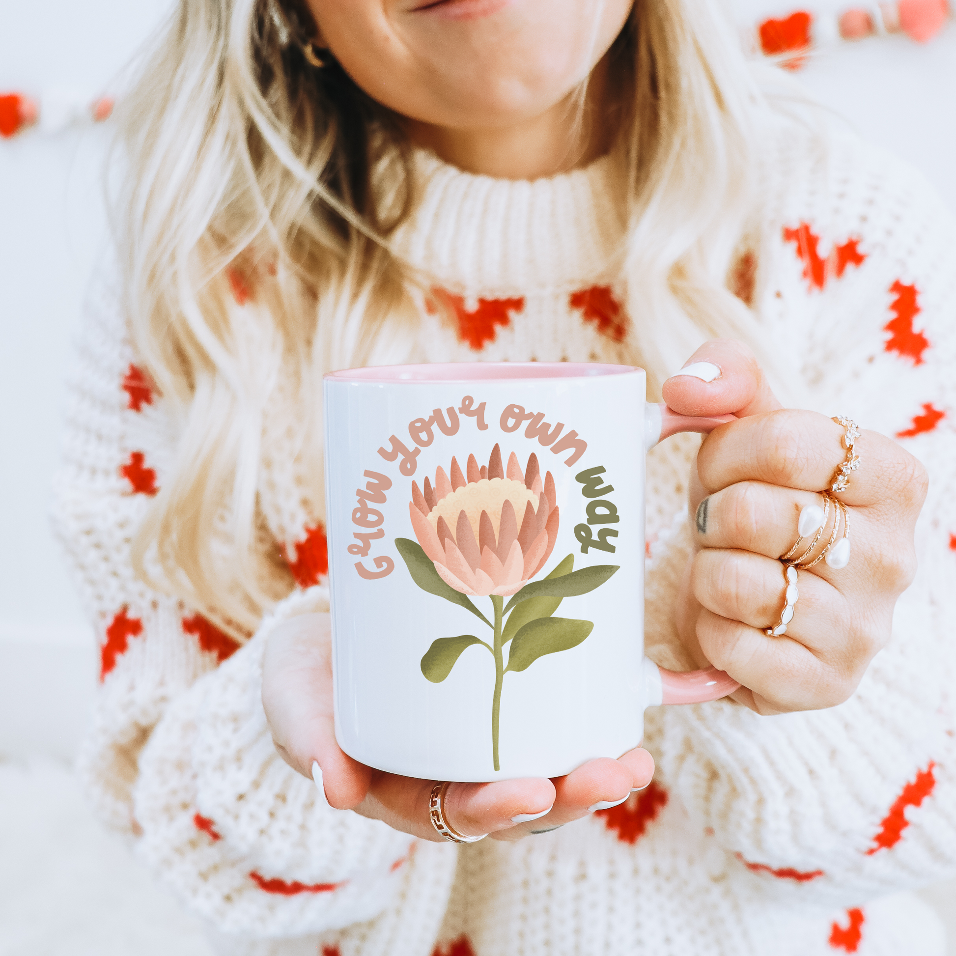 Frau mit Tasse in der Hand - Tasse mit Protea Blume und dem Schriftzug Grow your own way